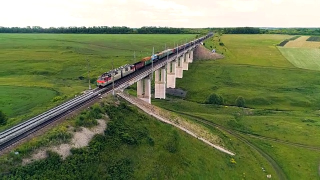 一列货运火车穿过一座铁路桥。视频素材