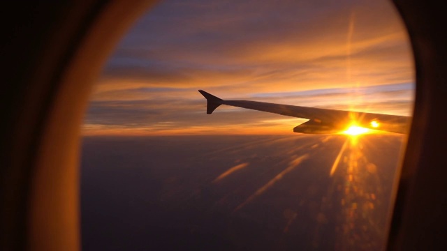 日落飞行与飞机机翼从飞机窗口视频下载
