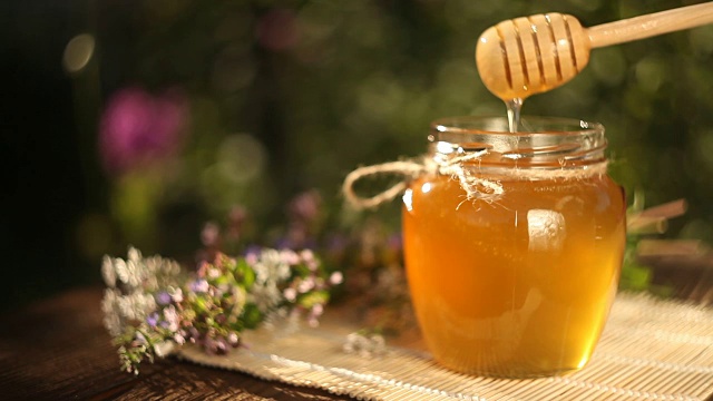美味可口的蜂蜜在罐子在桌子上视频素材