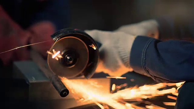 工人用手圆盘磨床磨料锯切割金属视频下载
