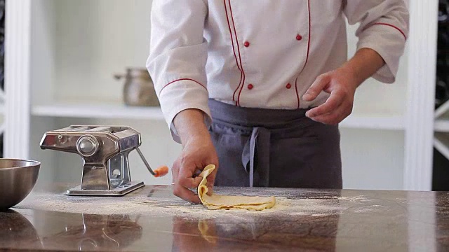 厨师用的是意大利面切割机。新鲜的意面从意面机里出来特写，慢莫视频素材