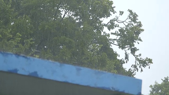 机架聚焦，大雨打在建筑屋顶上视频下载