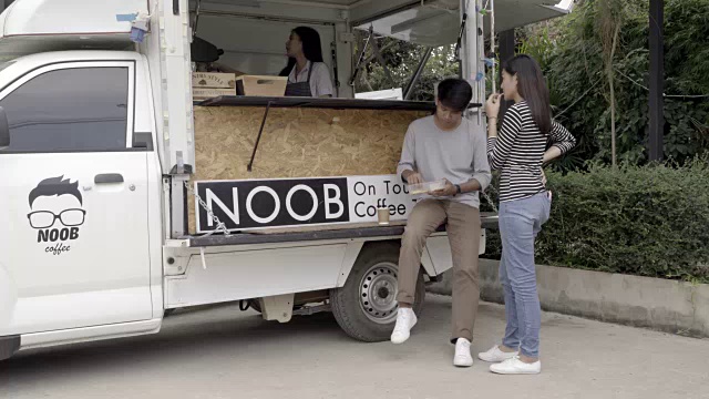 千禧一代的年轻人在食品卡车上买食物和饮料视频素材
