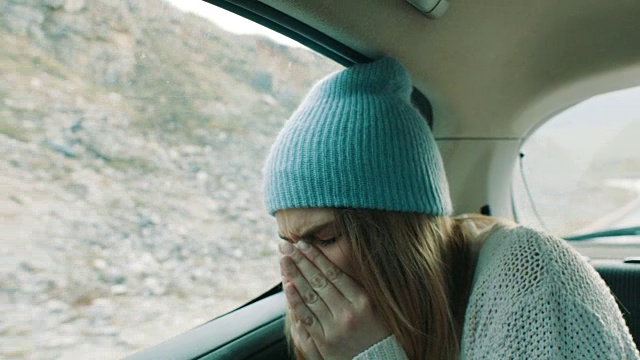 一个患感冒的女人坐在汽车后座上视频下载