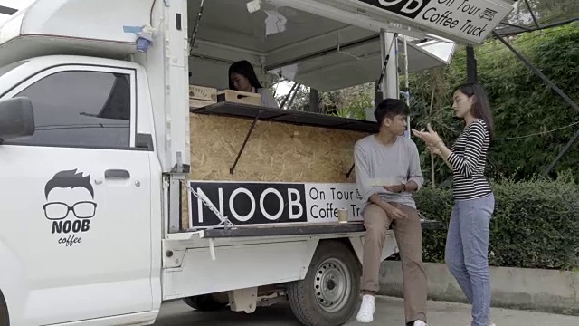 千禧一代的年轻人在食品卡车上买食物和饮料视频素材