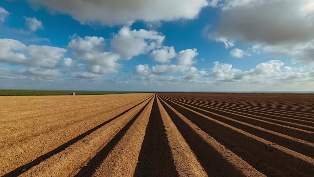 在法国诺曼底，犁沟般的农田准备种植作物和蔬菜。4K时间间隔。田园风光，春日农田。环境友好型农业和工厂化农业理念视频素材