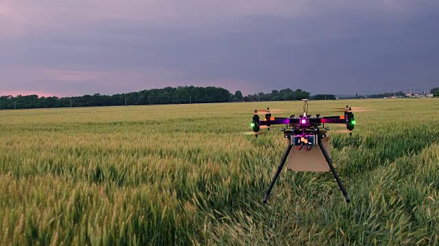 DS无人机带着包裹在田野中央起飞视频素材