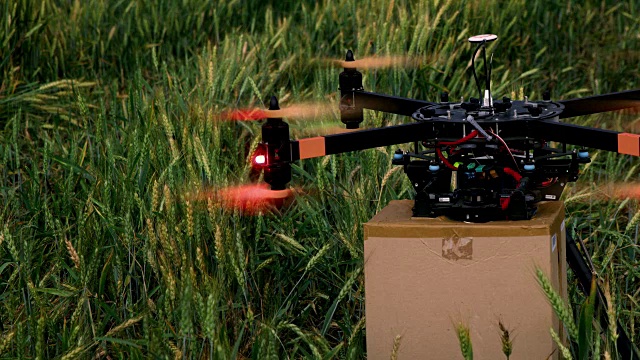 DS无人机带着包裹在田野中央起飞了视频素材