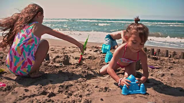 夏天，年轻的多民族朋友们在海滩上堆沙堡视频素材