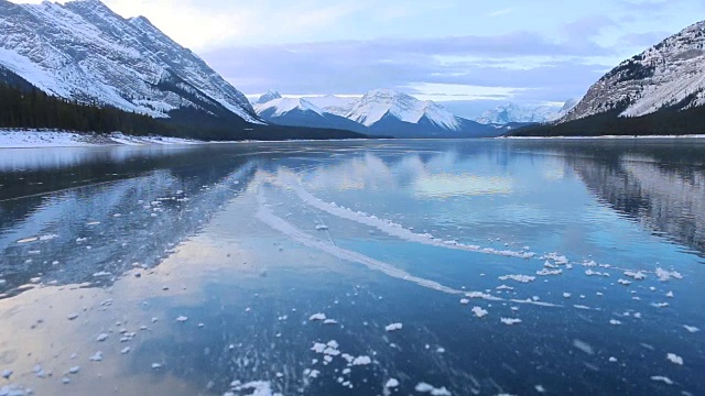 年轻人在美丽的山间湖泊上单飞溜冰视频素材