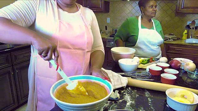 两个非裔美国妇女在厨房做饭视频素材