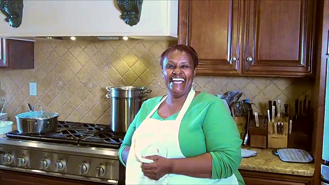 成熟的非裔美国妇女在厨房烘干双手视频素材