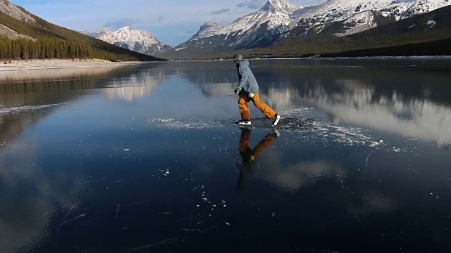 朋友们沿着冰冻的高山湖泊滑冰，去吃冰鱼视频素材