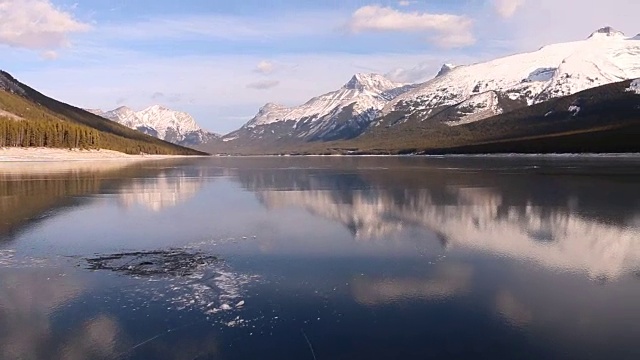 朋友们沿着冰冻的高山湖泊滑冰，去吃冰鱼视频素材