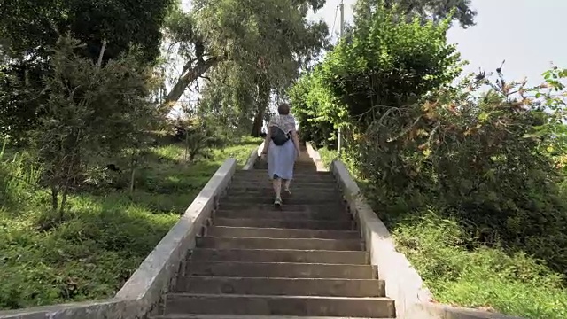 在热带植物园的楼梯上走着的年轻女孩。巴统,格鲁吉亚视频素材