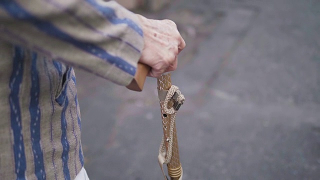 特写:慢镜头:一位亚洲老妇人早上拄着拐杖散步锻炼。视频下载