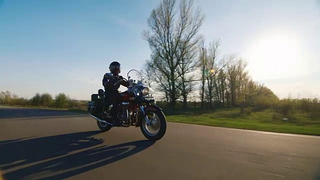 骑摩托车在乡间小路上，阳光照在上面视频素材