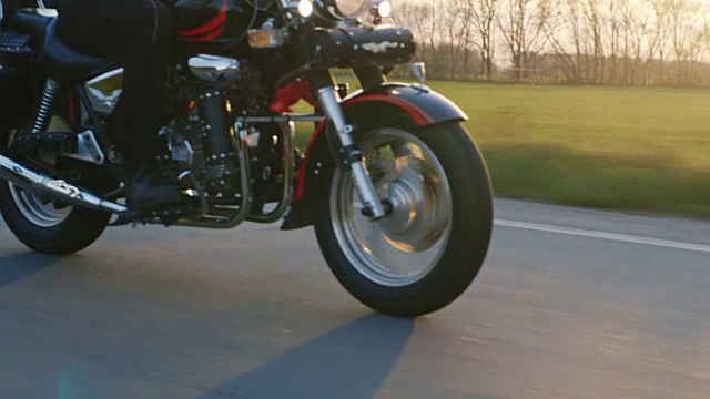 摩托车的轮子，很快地在路上走，太阳照耀，给一个很好的眩光视频素材