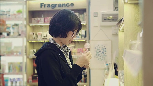 亚洲年轻女孩在商店的货架上选择项目视频素材