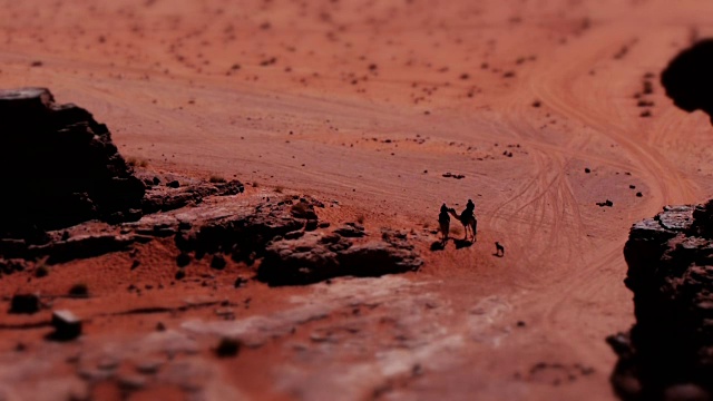 迷你效应——中东约旦瓦迪拉姆沙漠的小贝都因人对骆驼的影响。Tilt-Shift。视频素材