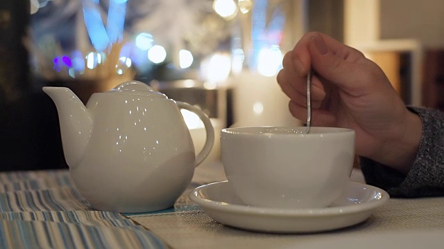 城市咖啡馆桌上的白色茶壶和茶杯。视频素材