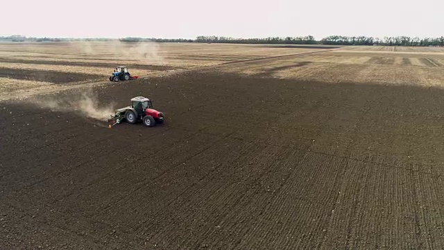 红色拖拉机播种机在试验田的土壤中播种。鸟瞰图视频下载