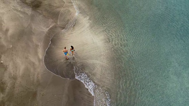 鸟瞰图的夫妇放松在海滩上视频素材