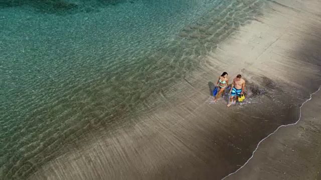 在海滩上散步的夫妇鸟瞰图视频素材