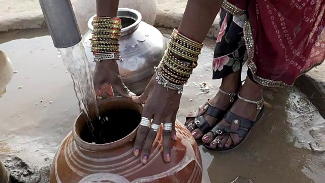 在拉贾斯坦邦沙漠收集清洁水的妇女。视频下载