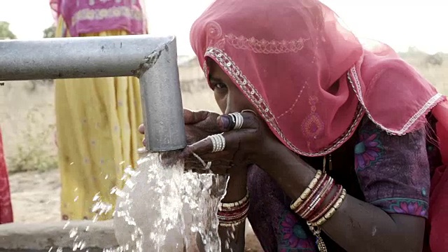 在拉贾斯坦邦沙漠收集清洁水的妇女。视频下载