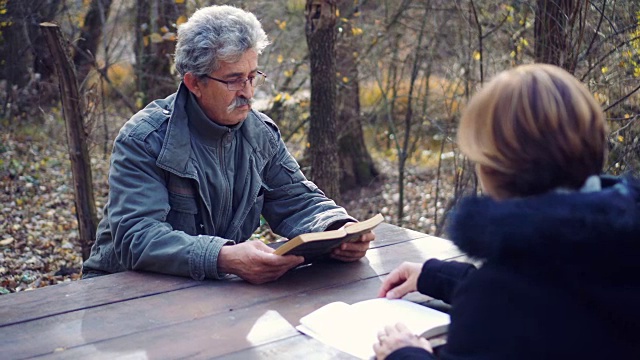 一对退休的老夫妇在大自然中读书视频素材