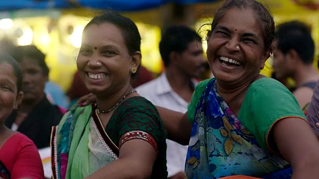 在繁忙的孟买市场里，一群妇女对着镜头有说有笑。视频素材