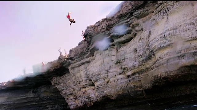 一个人翻着筋斗跳悬崖，然后跳进海里视频素材
