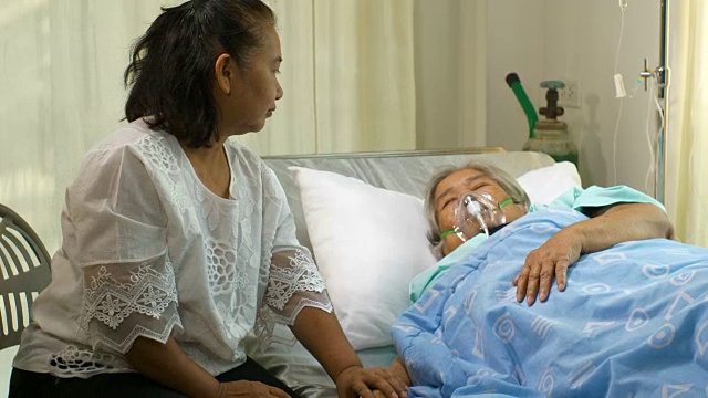 一位妇女在医院的病床上看着她的妈妈视频素材