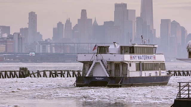 两艘纽约水道渡船驶上结冰的哈德逊河，以城市为背景。视频素材