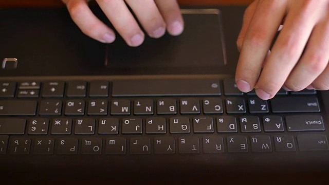俯视图的自由职业者的手打字在笔记本电脑键盘在咖啡馆。在办公室工作的商人。一名男子在一家咖啡店上网搜索信息。商业和技术概念视频素材