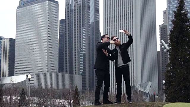 两个朋友在用智能手机自拍视频，背景是芝加哥的天际线。视频素材