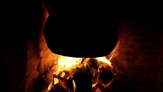 黑色的锅在壁炉的温暖下炖着燃烧的木头视频下载