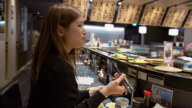 日本东京，一位女士在一家餐馆吃寿司视频素材