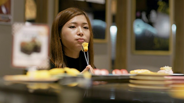 日本东京，一个女人在一家餐馆吃寿司视频素材