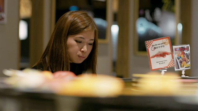 日本东京，一个女人在一家餐馆吃寿司视频素材