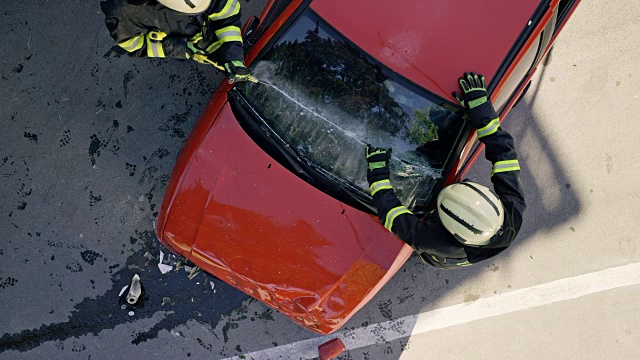 在一场事故中，两名消防员划破了一辆汽车的挡风玻璃视频下载