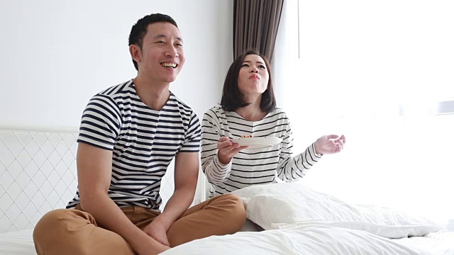 年轻夫妇在家里吃零食，享受他们的爱情和婚姻-股票视频视频素材