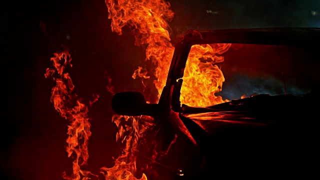 SLO MO LD汽车在夜晚被滚滚的火焰吞没视频素材