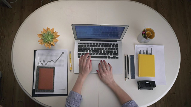 商务女性打开笔记本电脑，站在白色的桌子上，输入文字，然后关上笔记本电脑。前视图。手关闭视频下载