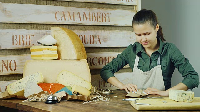 一个年轻的女人在柜台上包着一块奶酪视频下载