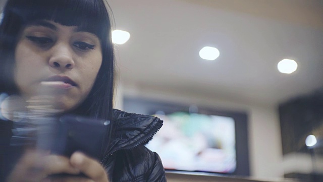 单身年轻女子在智能手机上聊天。视频下载