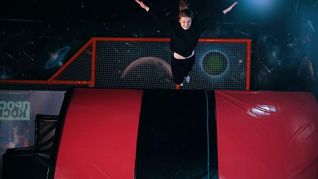 年轻女子杂技体操运动员从顶端跳到柔软的泡沫立方体，慢动作视频下载