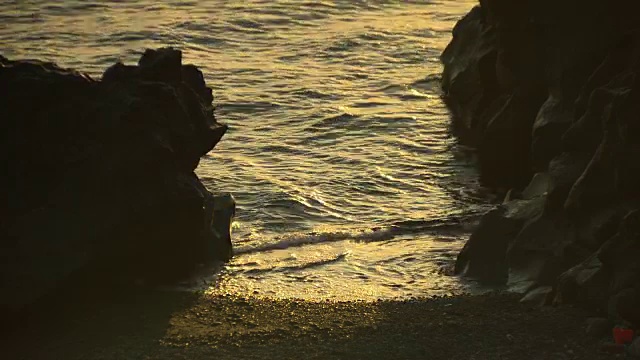 意大利，日出时，第勒尼安海的轻柔海浪拍打着岩石之间的海岸。视频素材