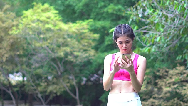 亚洲年轻女子在公园玩短信视频素材